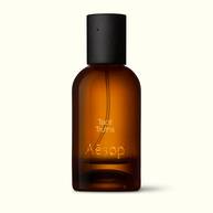 Amber glass Aesop Tacit Truths Eau de Parfum bottle with black cap on a white background.